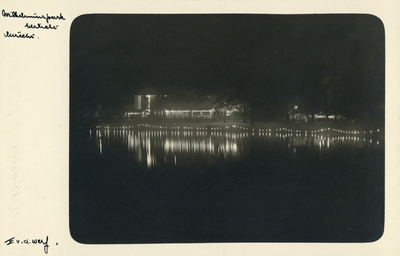 99297 Gezicht op de verlichte vijver in het Wilheminapark te Utrecht, bij avond; op de achtergrond het theehuis van de ...